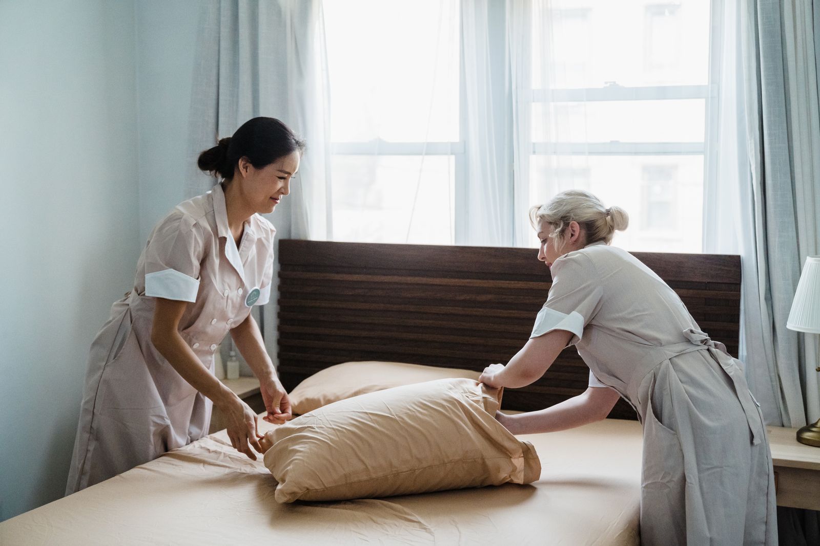 Two Brightwell team members making a bed